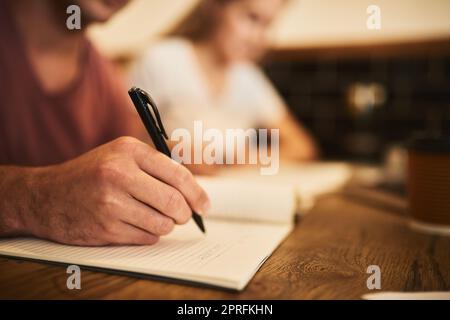 En prenant en compte tous les détails importants, deux étudiants non identifiables ayant une session d'étude à une table de café. Banque D'Images