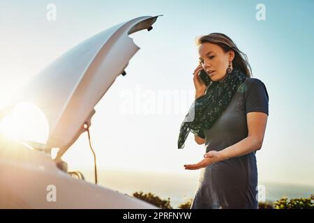 Je ne peux pas dire quel est le problème : une jeune femme qui appelle l'assistance routière après avoir fait panne. Banque D'Images