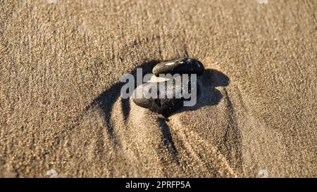 Pierre en forme de coeur dans le sable de la plage sur la mer Baltique Banque D'Images