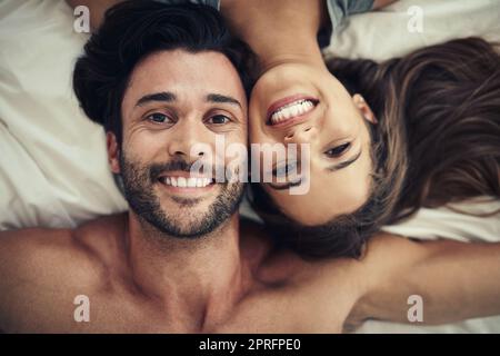 Il n'y a pas de place ID plutôt être. Un jeune couple affectueux se reposant au lit ensemble. Banque D'Images