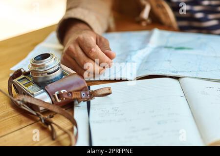 HES a passé une journée entière à explorer à l'avance. Un touriste inidentifiable regardant des cartes et des journaux de voyage tout en étant assis sur une petite table. Banque D'Images