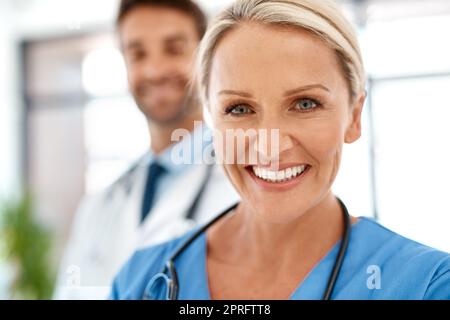 Faites confiance à nous. Portrait de deux heureux professionnels de la santé se posant ensemble dans un hôpital. Banque D'Images