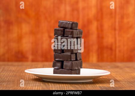 Assiette avec une tour de bonbons au chocolat doux Banque D'Images