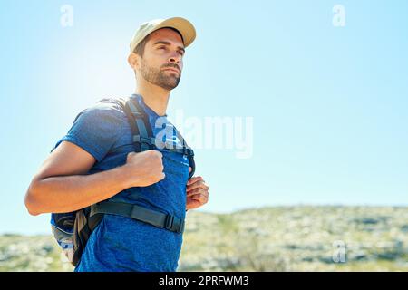 Départ pour atteindre de plus grands sommets. Un jeune homme sur une randonnée. Banque D'Images