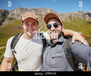 Selfie d'hommes ou d'amis de randonnée heureux dans la montagne ou la nature sur les vacances Voyage en été ou au printemps ensemble. Portrait de jeunes touristes souriant ou souriant lors d'un voyage d'aventure de trekking Banque D'Images