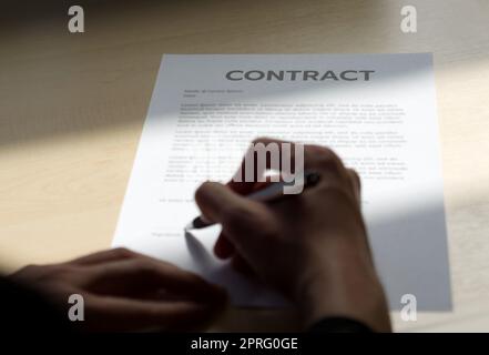 Document contractuel sur table en bois avec lumière du soleil brille dessus. Banque D'Images