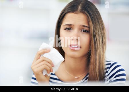 Les allergies vous ont fait tomber. Portrait d'une jeune femme souffrant d'allergies tenant un tissu à la maison. Banque D'Images