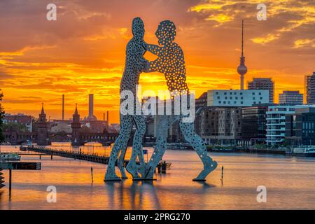 Coucher de soleil à Berlin avec la rivière Spree, la sculpture Molecule Men et la tour de télévision Banque D'Images