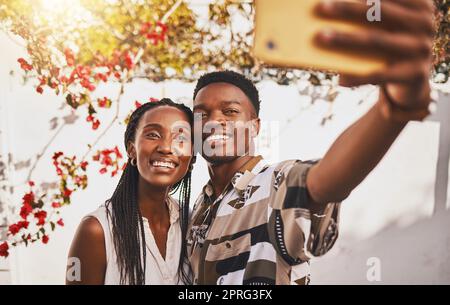 L'homme et la femme aiment prendre un portrait de selfie ensemble comme un couple souriant pendant l'été sous un soleil relaxant. Joyeux, sourire et gratuit petit ami et jeune amie prendre des photos sur téléphone pour les médias sociaux Banque D'Images