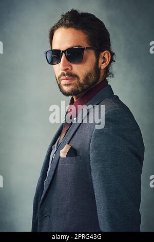 Quand vous êtes aussi cool... Portrait de studio d'un jeune homme élégant habillé portant des lunettes de soleil. Banque D'Images