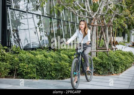 une jeune femme d'affaires avec casque à vélo va au travail de bureau Banque D'Images