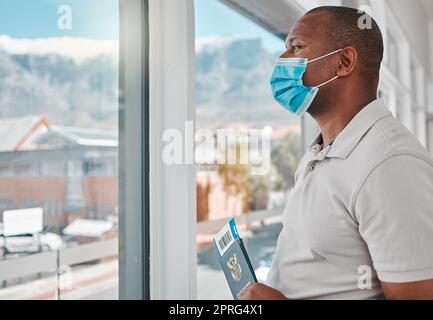 Homme à l'aéroport avec un passeport covid, un visa de voyage et un masque pour le vol d'avion de l'immigration internationale. Touristes, voyageurs et passagers attendant à la fenêtre le départ de l'avion en cas de pandémie de corona Banque D'Images