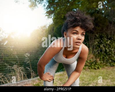 Commencer n'importe quoi est le début. Une jeune femme sportive prenant une pause après sa course. Banque D'Images