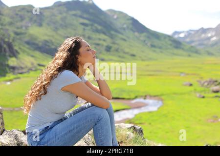 Femme se détendant dans une vallée de montagne Banque D'Images