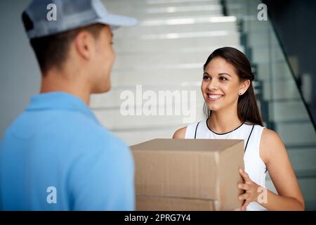 Merci pour votre livraison rapide. Une femme d'affaires qui reçoit un colis du coursier. Banque D'Images