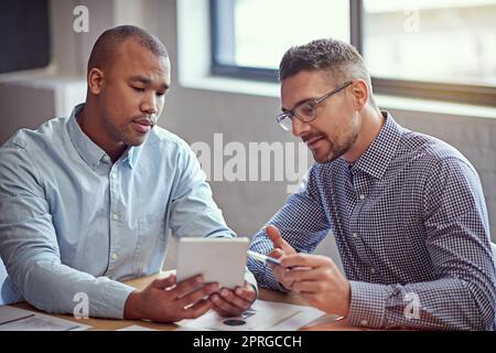 Utiliser la technologie pour améliorer leur entreprise. Photo de deux concepteurs travaillant sur une tablette numérique dans un bureau. Banque D'Images