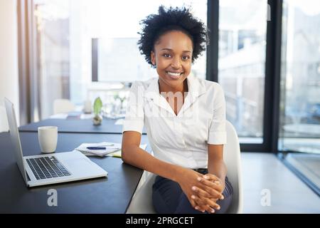 Je ne peux pas imaginer faire des affaires sans la technologie à mes côtés. Portrait d'une jeune femme d'affaires confiante travaillant sur un ordinateur portable dans un bureau moderne. Banque D'Images