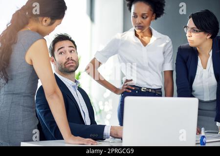 HES a eu quelques explications à faire : un groupe d'hommes d'affaires s'est rassemblé autour d'un ordinateur dans leur bureau. Banque D'Images