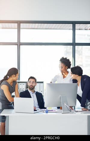 Ils n'ont pas l'air heureux. Un groupe de gens d'affaires se sont rassemblés autour d'un ordinateur dans leur bureau. Banque D'Images