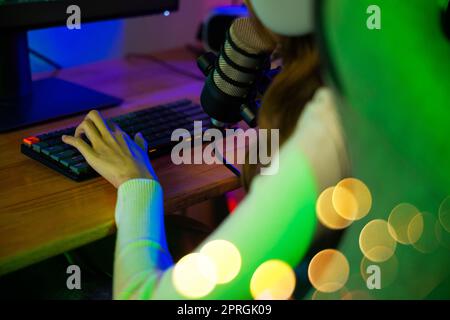 gamer femme appuyer sur le clavier pour jouer à des jeux vidéo en ligne sur l'ordinateur elle en direct et de chat avec les fans Banque D'Images