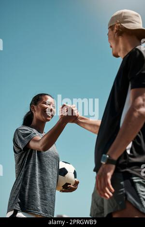 Poignée de main, football et motivation de l'équipe, but de jeu et fête de la concurrence avec ciel bleu maquette pour le marketing ou la publicité. Inclusion, soutien et Banque D'Images