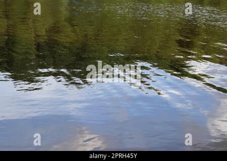 Surfaces d'eau avec vagues et ondulations et la lumière du soleil se reflétant à la surface. Banque D'Images