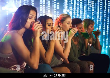 Un groupe de jeunes femmes qui boivent des cocktails lors d'une fête. Banque D'Images