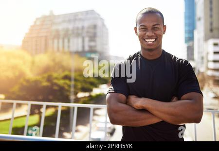 A été ravivé pour cette course. Portrait d'un jeune sportif debout avec ses bras repliés à l'extérieur. Banque D'Images