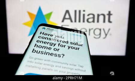 Smartphone avec le site Web de la société américaine alliant Energy Corporation à l'écran devant le logo de l'entreprise. Faites la mise au point dans le coin supérieur gauche de l'écran du téléphone. Banque D'Images