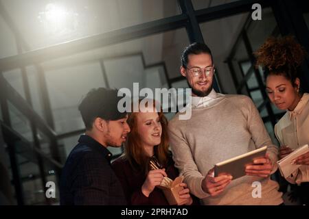 Jeunes designers au travail. Un groupe de jeunes designers travaillant tard au bureau. Banque D'Images