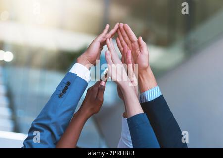 Unis pour le succès. Un groupe de personnes qui mettent leurs mains ensemble dans l'unité. Banque D'Images