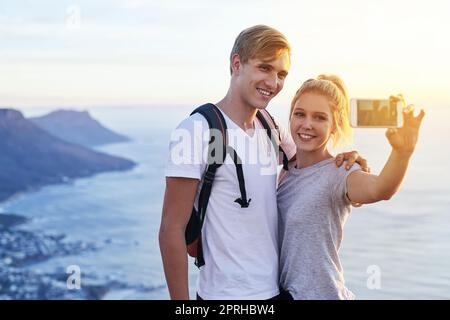 Prise d'un selfie sur le sommet de la montagne. Un jeune couple prend un selfie pendant une randonnée. Banque D'Images