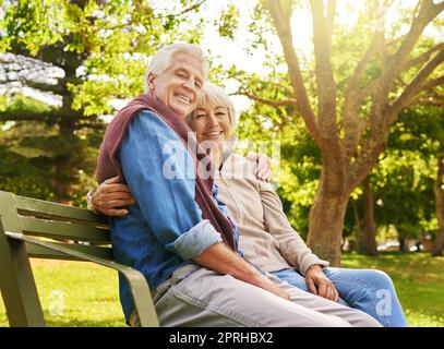 La relaxation commence maintenant. Portrait d'un couple senior heureux se reposant sur un banc de parc. Banque D'Images