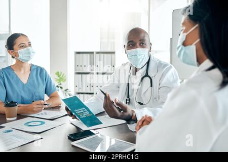 Équipe de médecins avec masque de consultation sur les résultats de covid avec la paperasserie et une tablette numérique. Les travailleurs de la santé discutent du vaccin, du traitement et de la médecine dans un bureau hospitalier. Banque D'Images