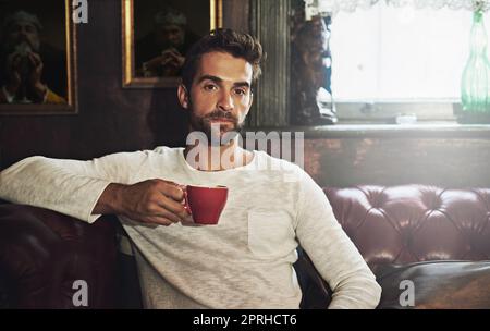 Il est temps de se détendre avec un cuppa joe. Portrait d'un beau homme ayant une tasse de café dans un café. Banque D'Images