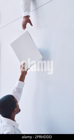 Le travail d'équipe est une question de soutien mutuel : un homme d'affaires transmet un document à un collègue dans un bureau. Banque D'Images