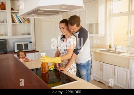 Partager un moment. Une famille heureuse debout dans une cuisine. Banque D'Images