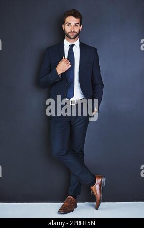 En matière d'affaires, assurez-vous de faire de votre mieux. Studio portrait d'un beau jeune homme d'affaires debout avec sa main dans sa poche sur fond gris. Banque D'Images