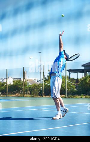 Il s'agit d'un ace. Un joueur de tennis masculin lance le ballon dans l'air pour un service - tennis Banque D'Images