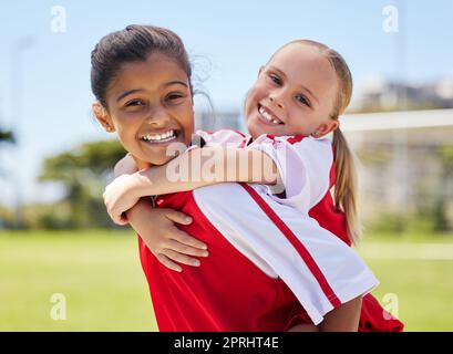 Équipe, sport et joueur de football filles avec un sourire heureux s'amuser sur un terrain de football en plein air. Portrait de bonheur des enfants avant un jeu sportif Banque D'Images