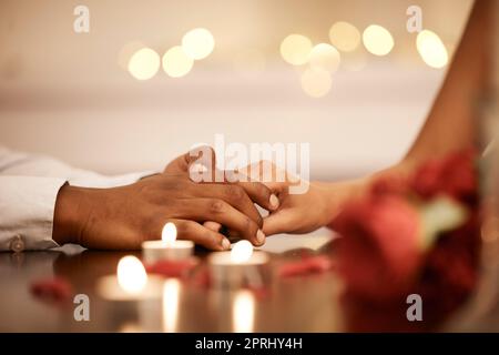 Couple holding hands at valentines table on date or romantic anniversary celebration together. Man touch black woman fingers, as expression of love at Stock Photo