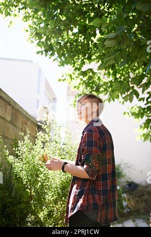 Des pensées qui fleurissent dans le jardin. Une courte photo d'une jeune femme magnifique debout dans son jardin Banque D'Images