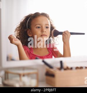 Je vais ressembler à ma momie. Une petite fille appliquant le blusher dans le miroir Banque D'Images