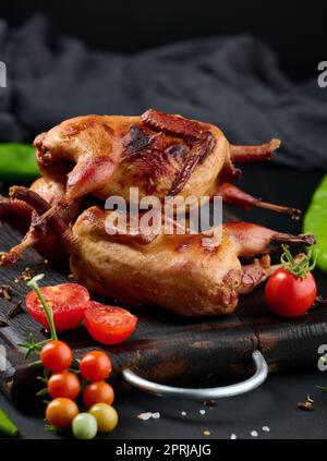 La friture des carcasses de cailles se trouve sur une planche de bois avec des légumes Banque D'Images