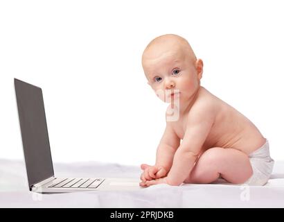 HES a déjà appris les moyens de la technologie. Photo studio d'un bébé garçon assis avec un ordinateur portable Banque D'Images