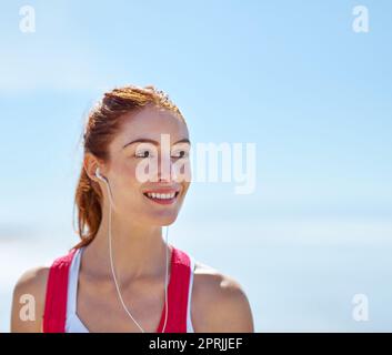 Il suffit de penser à un entraînement pour faire son sourire. Une jeune femme sportive sur la plage. Banque D'Images