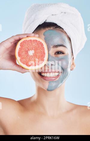 Soin de la peau, masque facial et pamplemousse avec une femme pendant sa routine de peau pour un teint propre et clair. Jeune modèle avec une alimentation saine aux fruits pour le visage avec des ingrédients naturels et un régime alimentaire pour la santé Banque D'Images