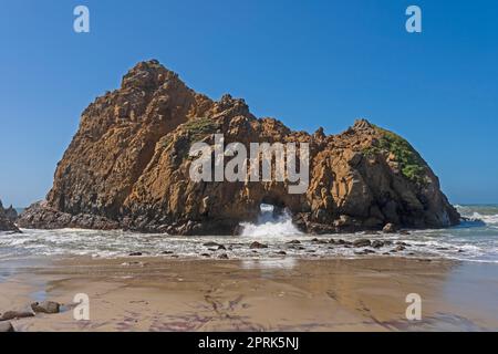 L'eau s'écrasant à travers une arche de mer à Pfeiffer Beach en Californie Banque D'Images