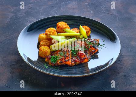 Côtes grillées avec concombre mariné et boulettes de pommes de terre frites Banque D'Images