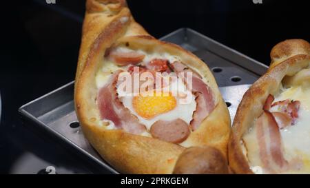 Une sorte de nourriture khachapuri avec du bacon et des saucisses Banque D'Images